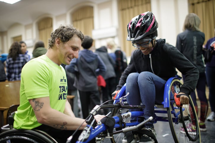 Josh George showing Rising New York Road Runners how to use a racing chair