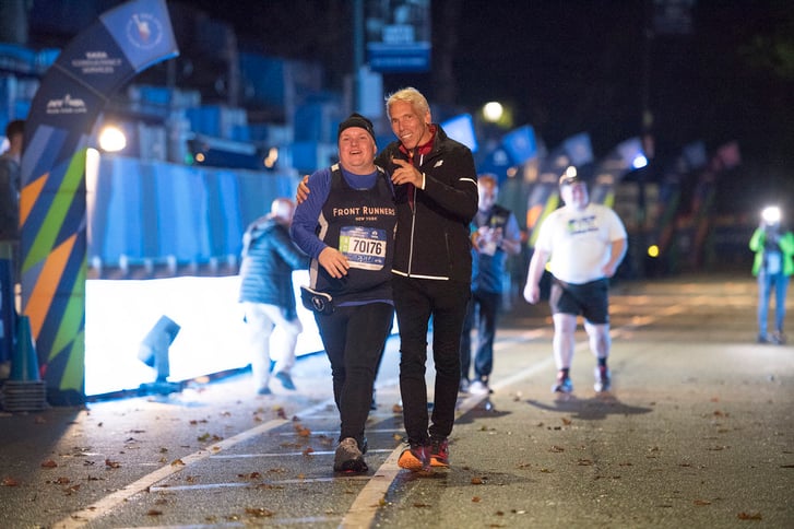 New York Road Runners Race Director Peter Ciaccia greeting a runner near the finish line of the New York City Marathon