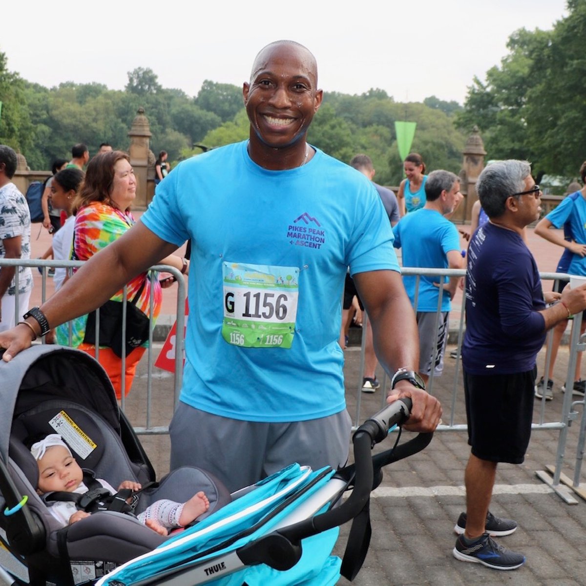A father after the Summer Community Run with his child in their stroller