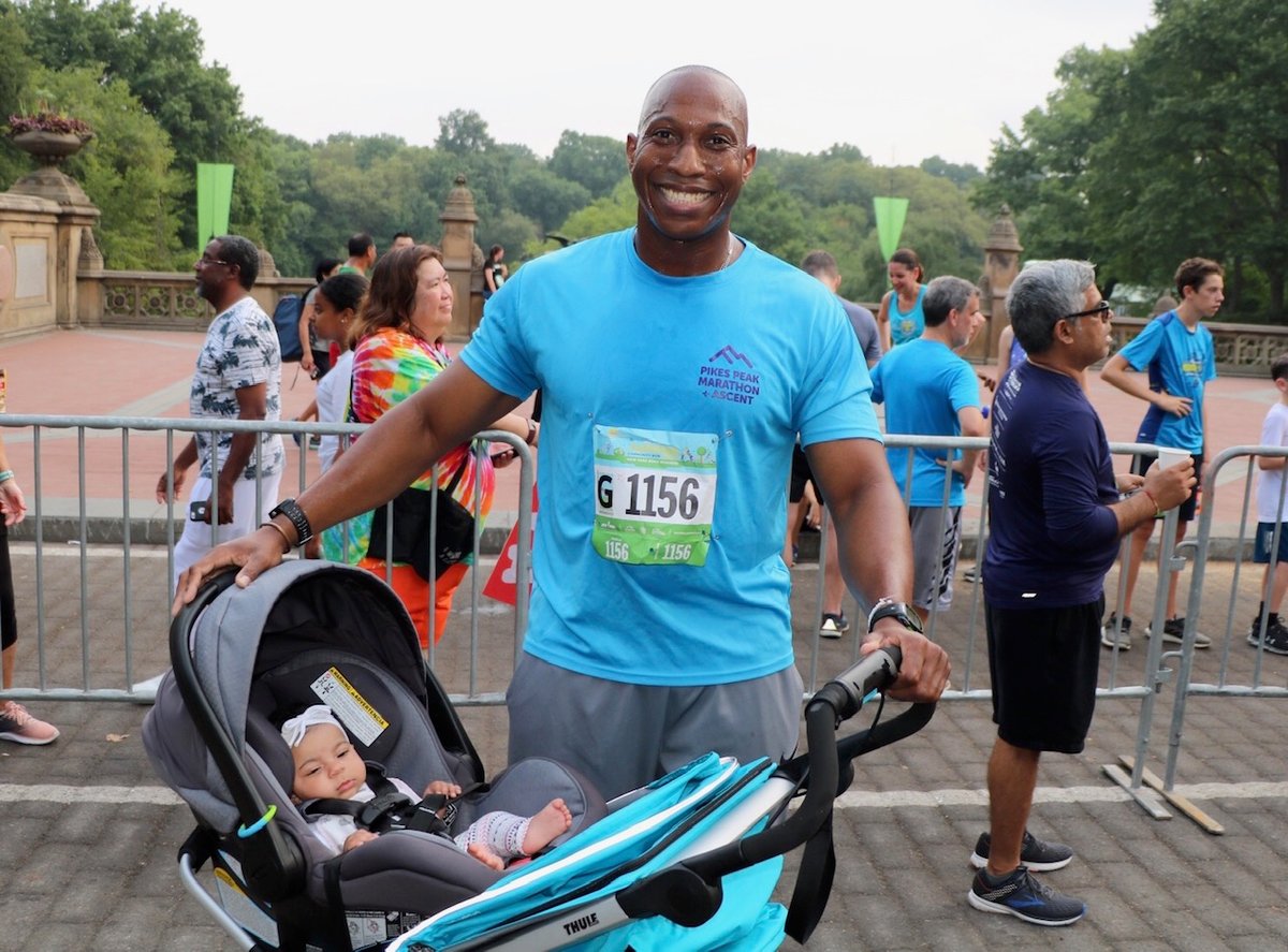 A father after the Summer Community Run with his child in their stroller