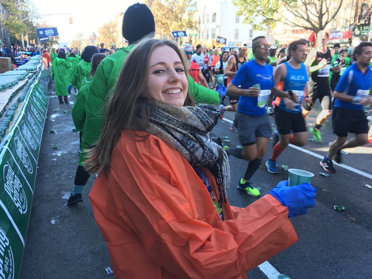 A volunteer with the Exchange Visitor Program hands out water during the TCS NYC Marathon.