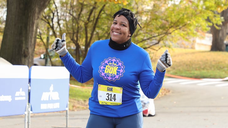 A woman running the NYRR 60K smiling during the race