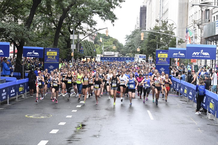 The starting line full of runners sprinting at the New Balance 5th Avenue Mile