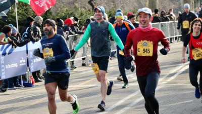 Three runners racing near the finish line.