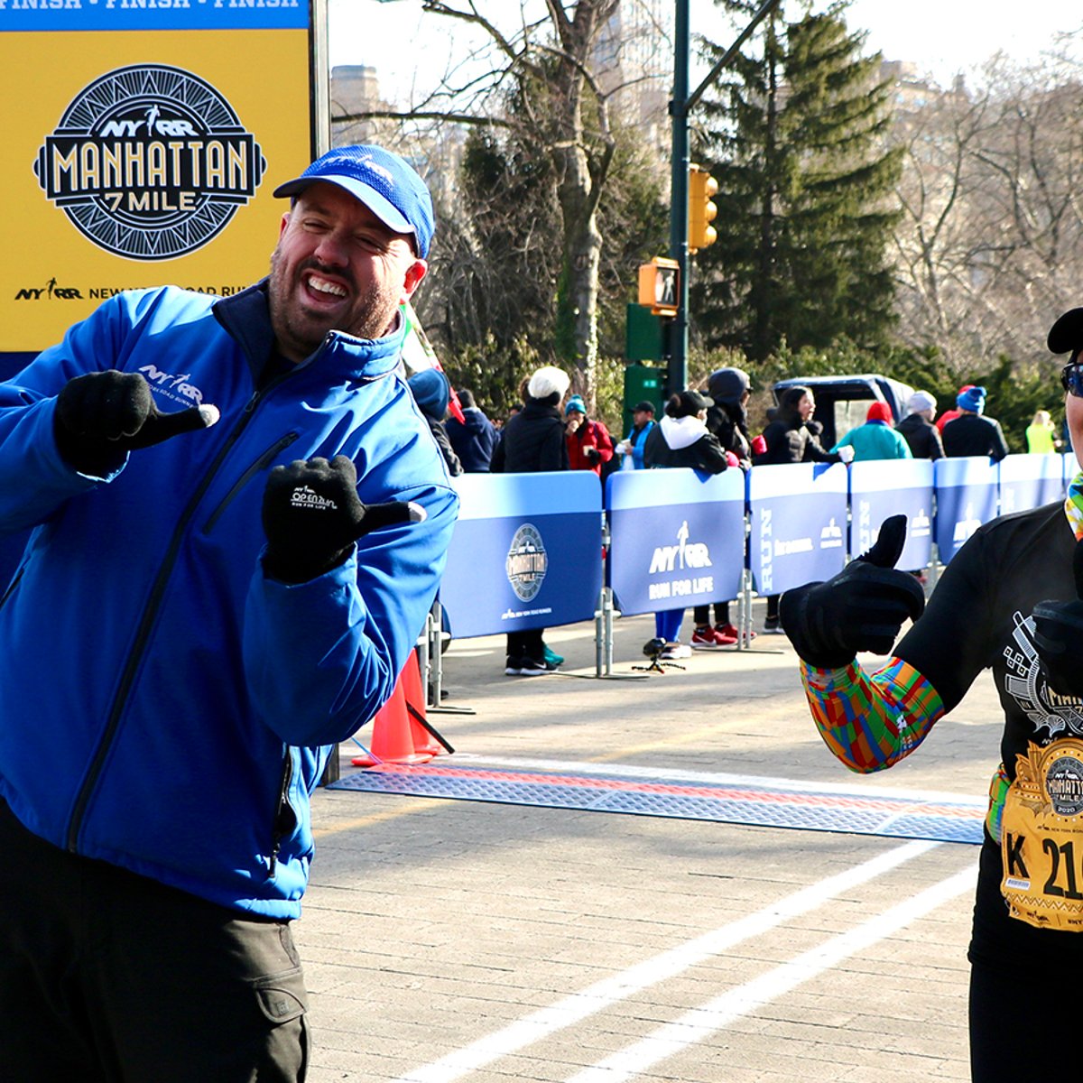 NYRR's Jim Heim with a runner at the finish line of the NYRR Manhattan 7 Mile