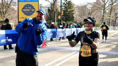 NYRR's Jim Heim with a runner at the finish line of the NYRR Manhattan 7 Mile