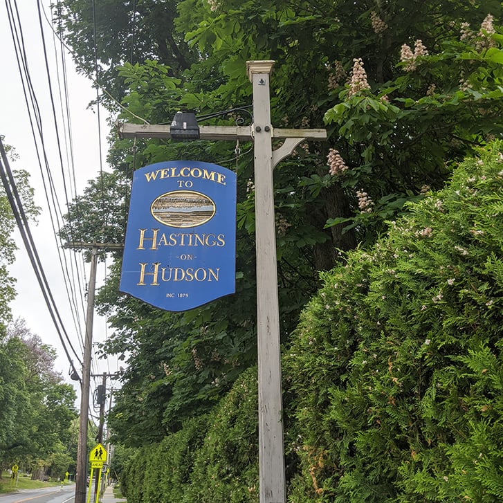 Hanging sign saying "Welcome to Hastings-on-Hudson"
