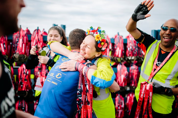 A volunteer hugging a runner after the Brooklyn Half