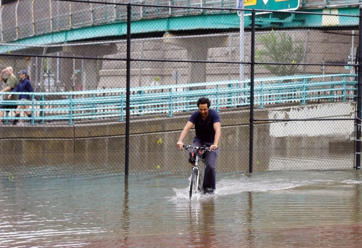 biker trying to pedal through flood waters