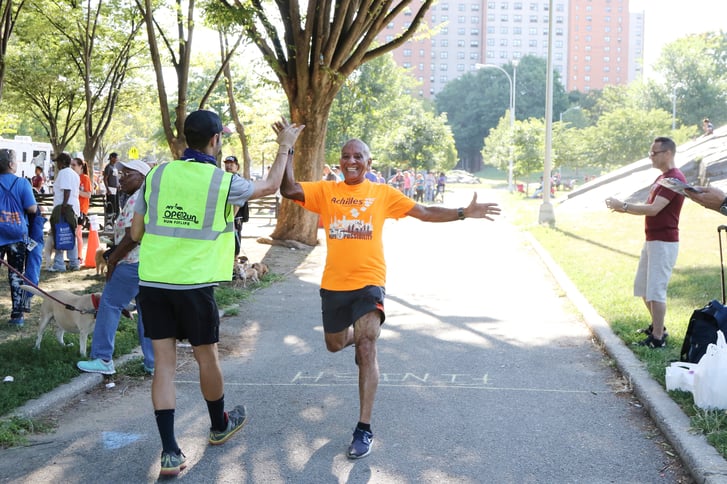Man completing an Open Run with NYRR volunteers