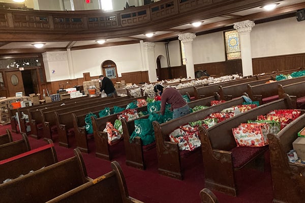 Volunteers in church sanctuary preparing food for distribution