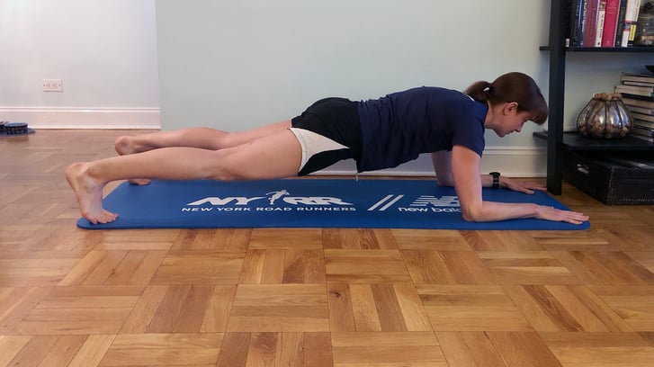 Runcenter Instructor Jen Ares-Cruz doing a plank in her home