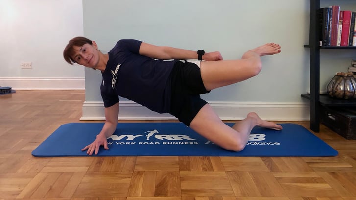 Runcenter Instructor Jen Ares-Cruz doing a side plank in her home