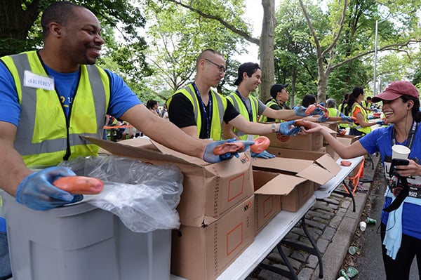 Jerry Nurse and other NYRR volunteers handing out bagels to runners