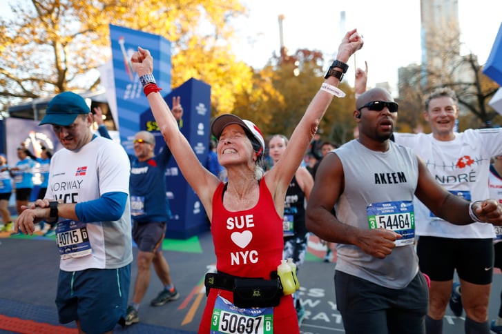 A runner celebrating after crossing the finish line of the New York City Marathon