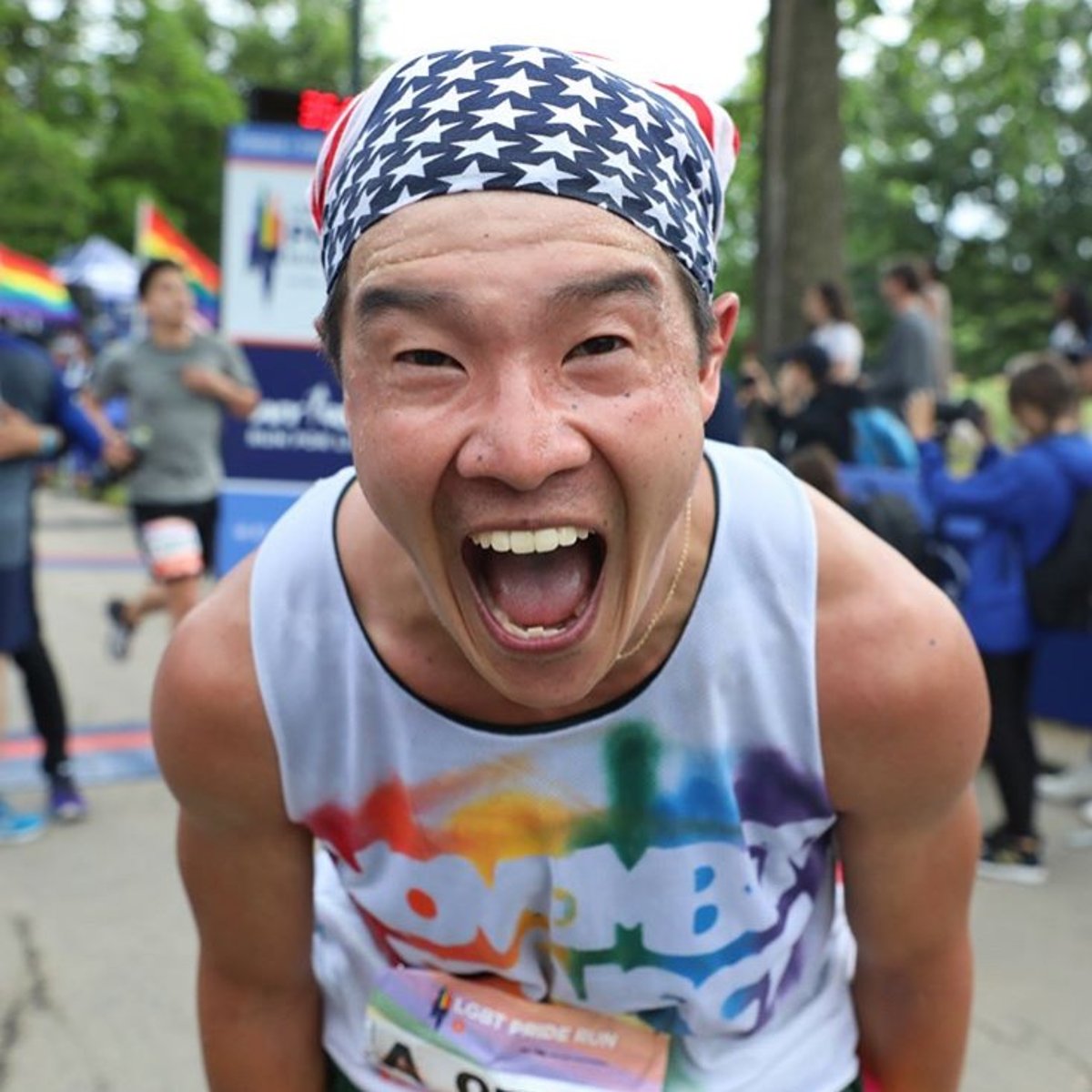 An NYRR staffer wearing a November Project singlet cheering at a race.