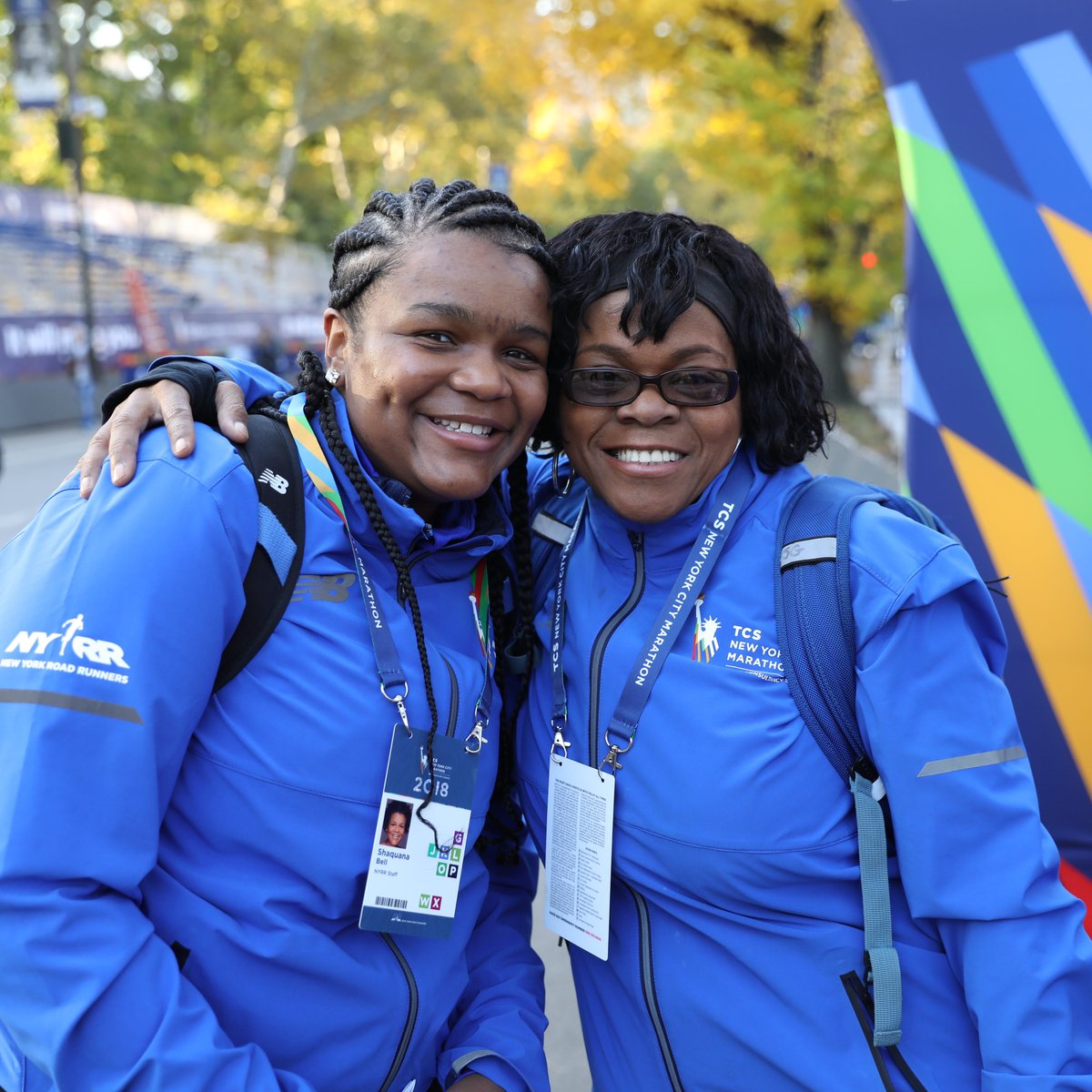 Two NYRR staffers smiling at the finish line of a race.