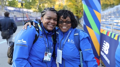 Two NYRR staffers smiling at the finish line of a race.