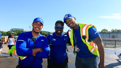 Three NYRR staffers at a race, smiling at the camera.