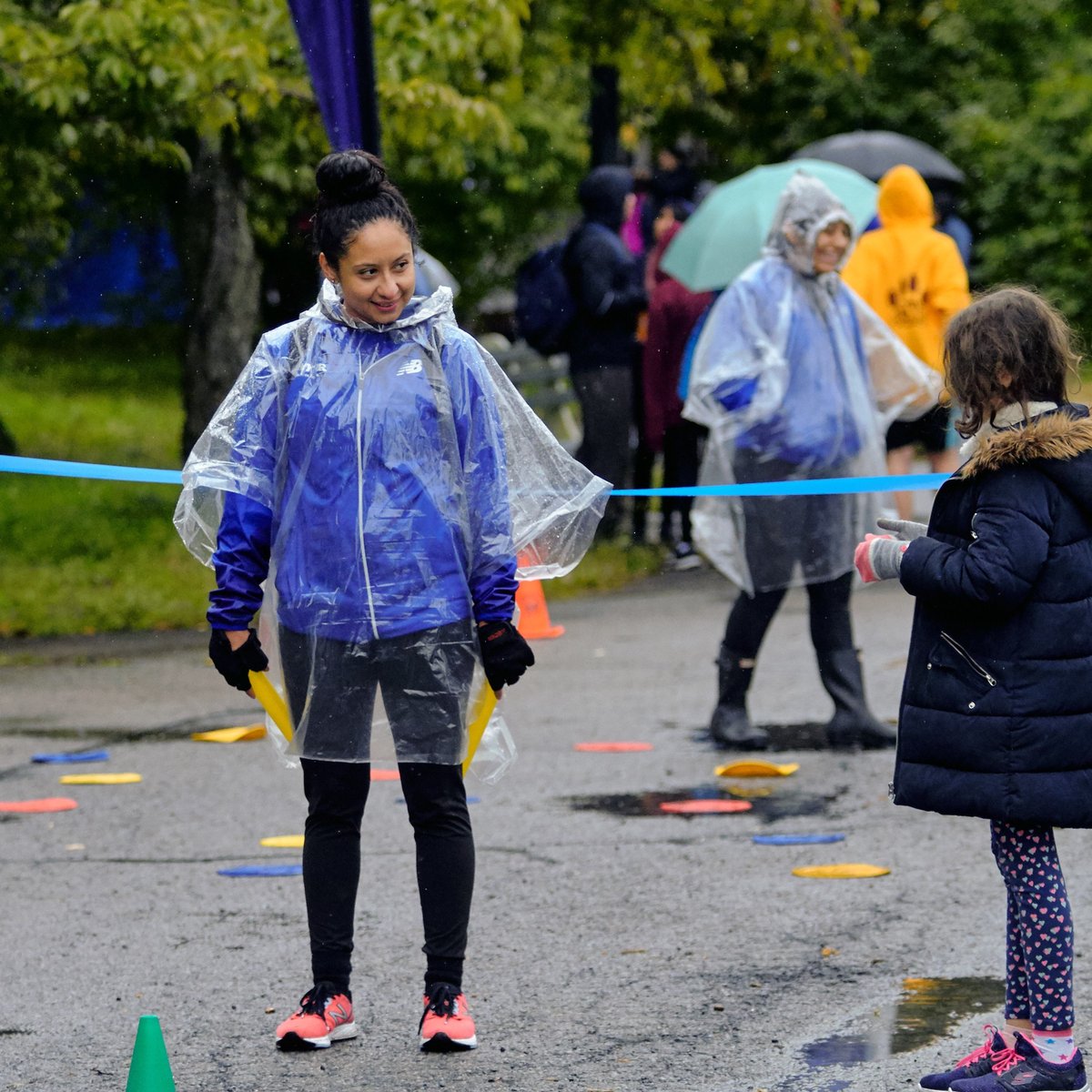 A NYRR staffer talking to two kids at an event.