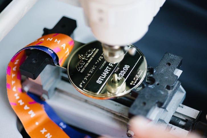 A TCS New York City Marathon medal being engraved
