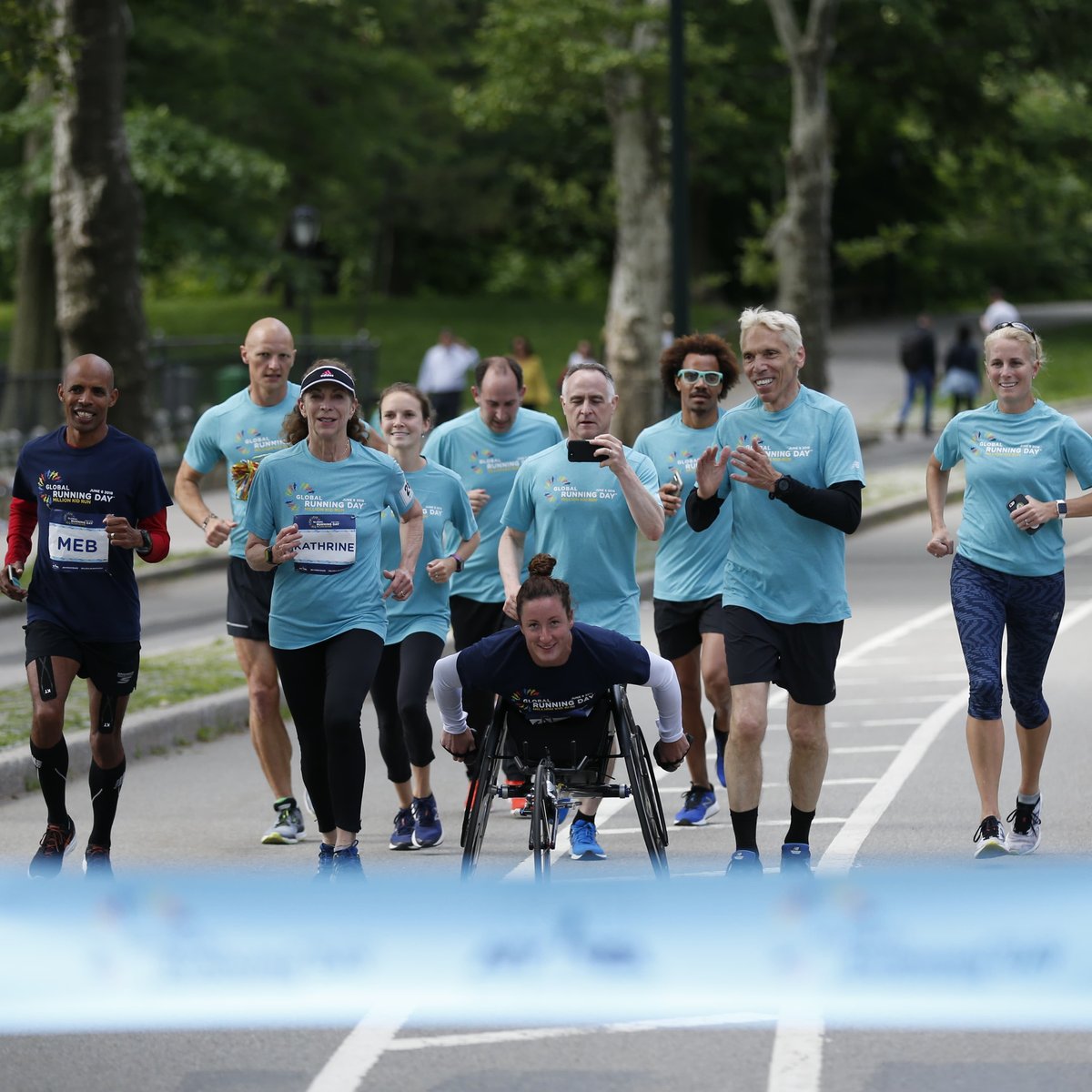 TCS New York City Marathon champions Kathrine Switzer, Tatyana McFadden and Meb Keflezighi, joined by NYRR Staff, approach the TCS New York City Marathon pop-up finish line, to finish to their NYRR Virtual Global Running Day 1M.