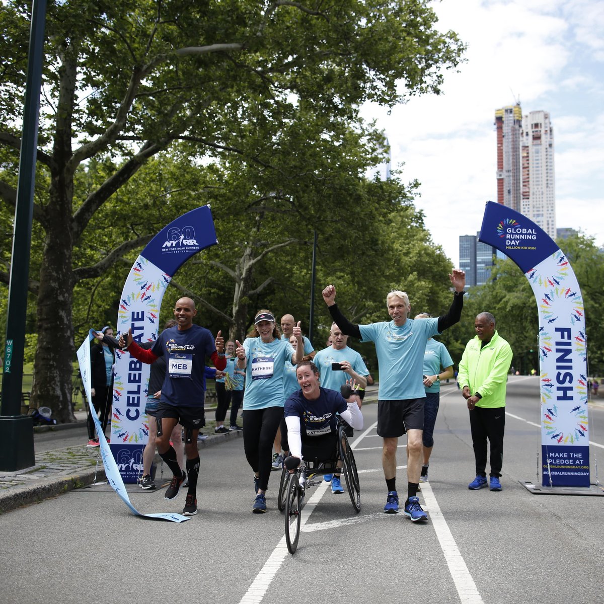 TCS New York City Marathon champions Kathrine Switzer, Tatyana McFadden and Meb Keflezighi, joined by NYRR Staff, break the tape at the TCS New York City Marathon pop-up finish line, to finish to their NYRR Virtual Global Running Day 1M.