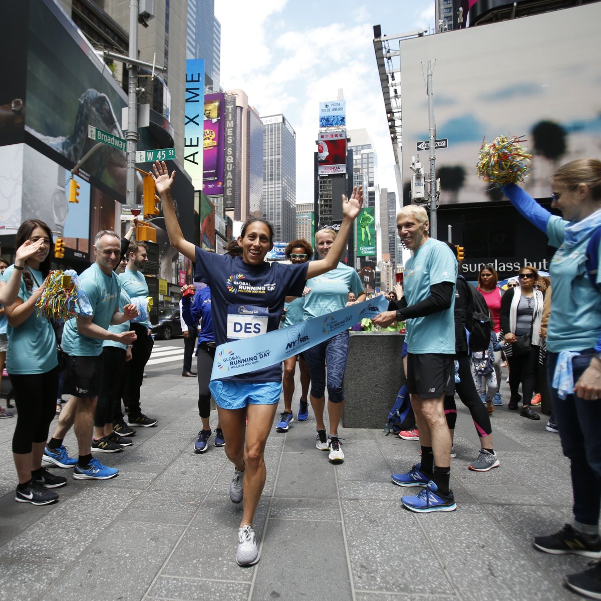 Des Linden breaks the tape at the pop-up finish line in Times Square to celebrate Global Running Day.