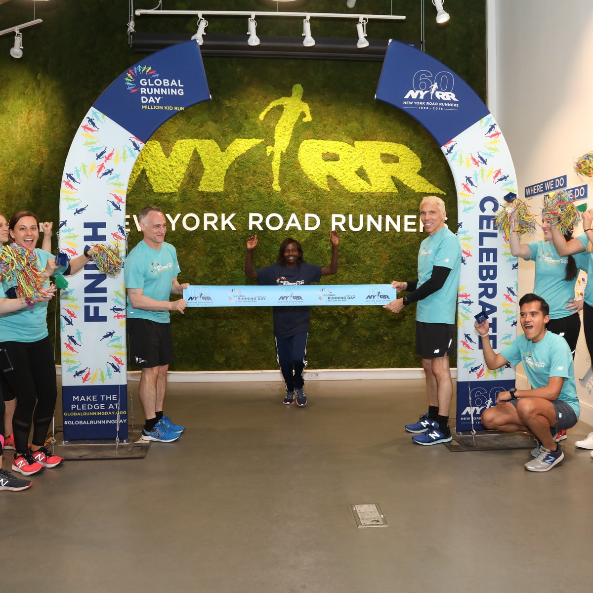 Three-time TCS New York City Marathon champion Mary Keitany breaks a pop-up finish line tape in honor of Global Running Day at the NYRR RUNCenter.