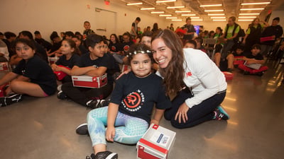 New Balance athlete Abbey D'Agostino distributes shoes on Global Running Day to Rising New York Road Runners as part of the 1 For You 1 For Youth program.