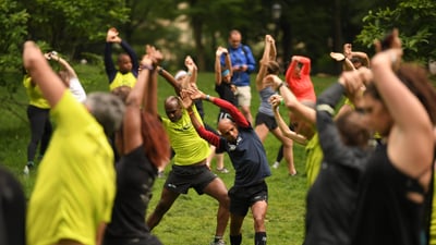 Team for Kids ambassador Meb Keflezighi joins in on a stretching session before heading out on a run through Central Park with Team for Kids runners on Global Running Day.