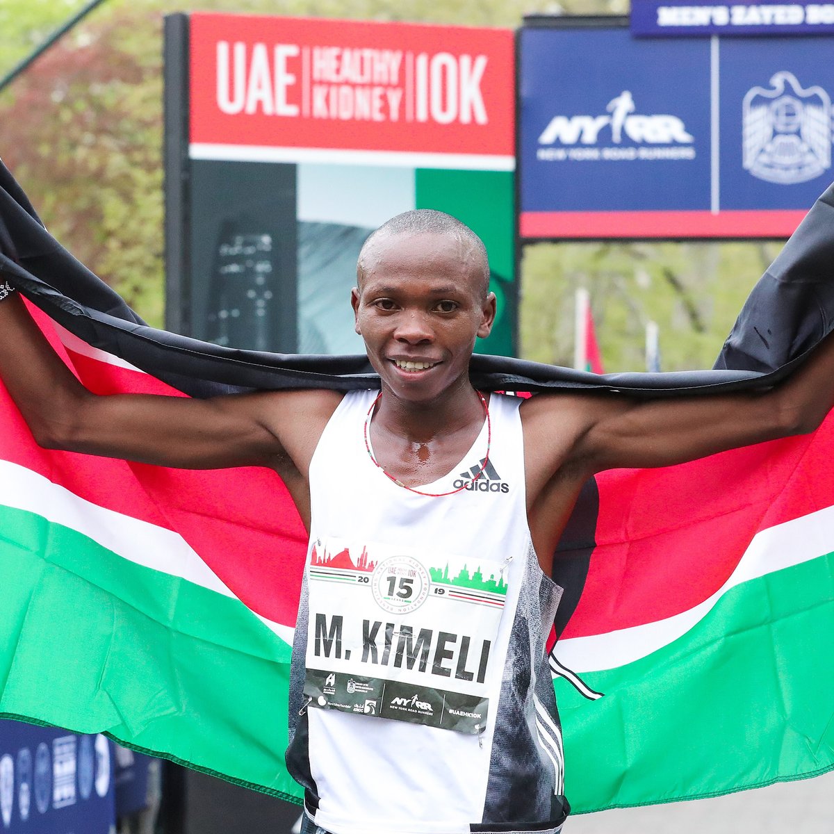 Men's first place finisher Mathew Kimeli poses with his nation's flag.