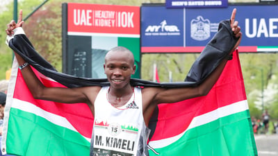 Men's first place finisher Mathew Kimeli poses with his nation's flag.