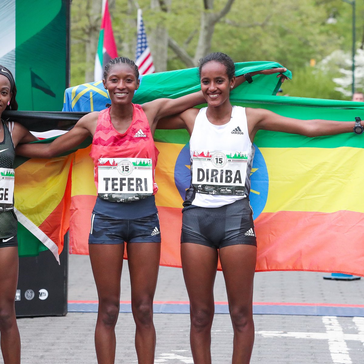 Women's top three finishers Senbere Teferi, Monicah Ngige, and Buze Diriba pose with their nation's flags.