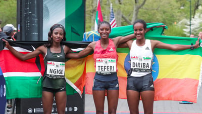 Women's top three finishers Senbere Teferi, Monicah Ngige, and Buze Diriba pose with their nation's flags.