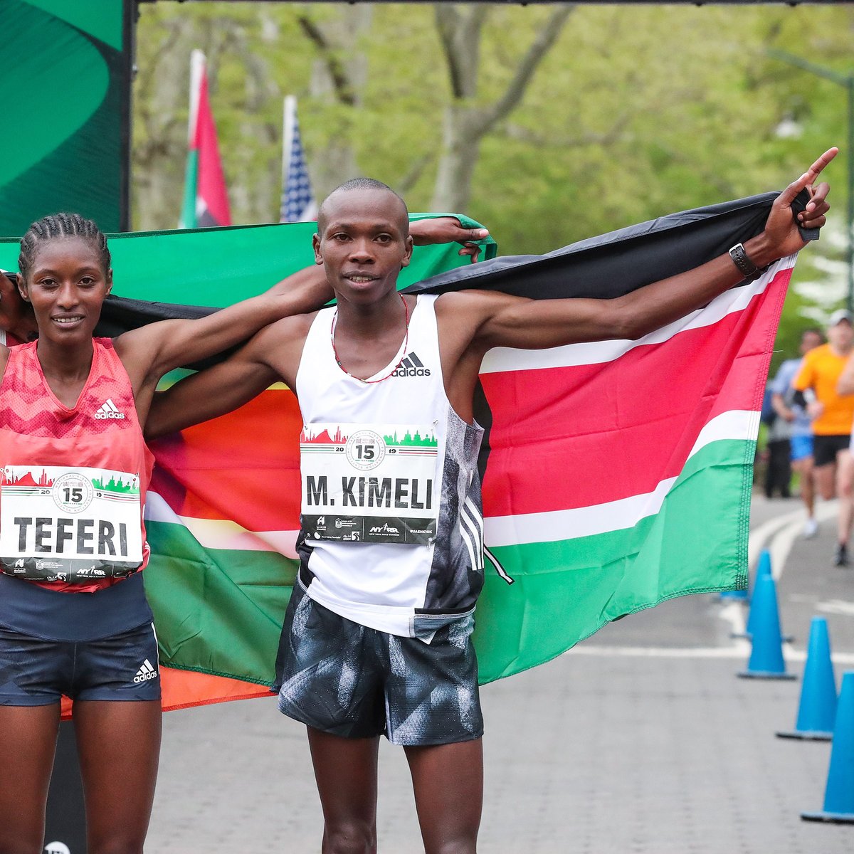 Men's and Women's first place finishers Mathew Kimeli and Senbere Teferi pose with their nations' flags.