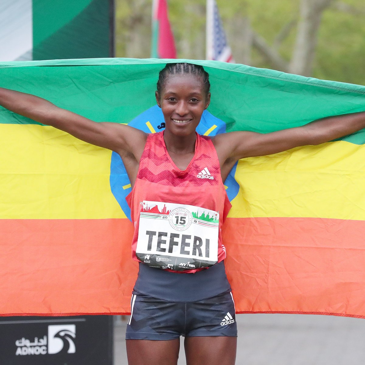 Women's first place finisher Senbere Teferi poses with her nation's flag.