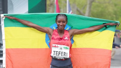 Women's first place finisher Senbere Teferi poses with her nation's flag.