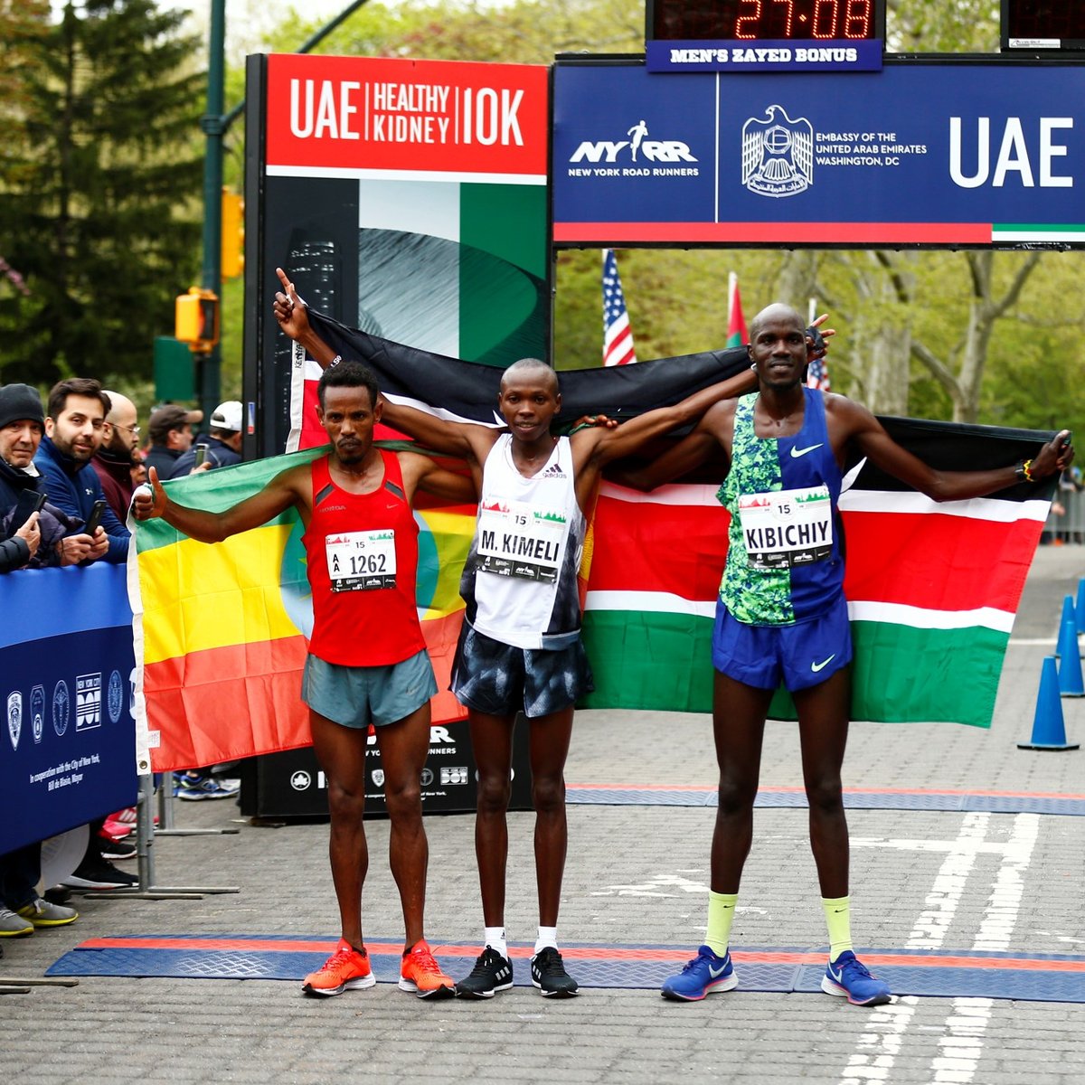 Men's first three finishers Mathew Kimeli, Girma Bekele Gebre, and Edwin Kibichiy pose with their nation's flags.