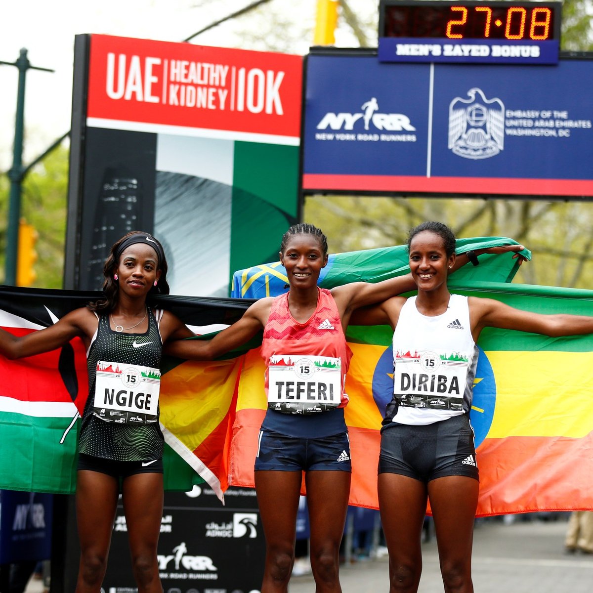 Women's top three finishers Senbere Teferi, Monicah Ngige, and Buze Diriba pose with their nation's flags.
