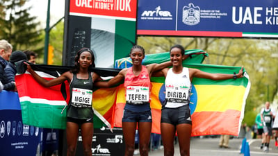 Women's top three finishers Senbere Teferi, Monicah Ngige, and Buze Diriba pose with their nation's flags.