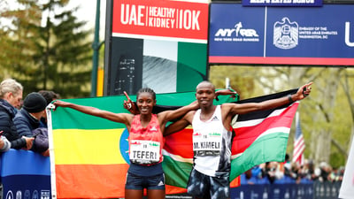 Men's and Women's first place finishers Mathew Kimeli and Senbere Teferi pose with their nations's flags.