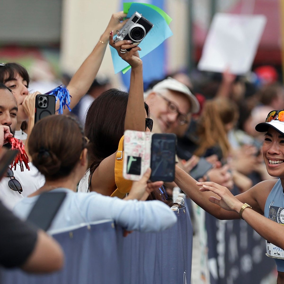 A runner meets people cheering for her at the sidelines of the RBC Brooklyn Half