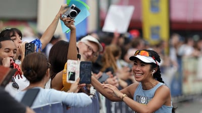A runner meets people cheering for her at the sidelines of the RBC Brooklyn Half