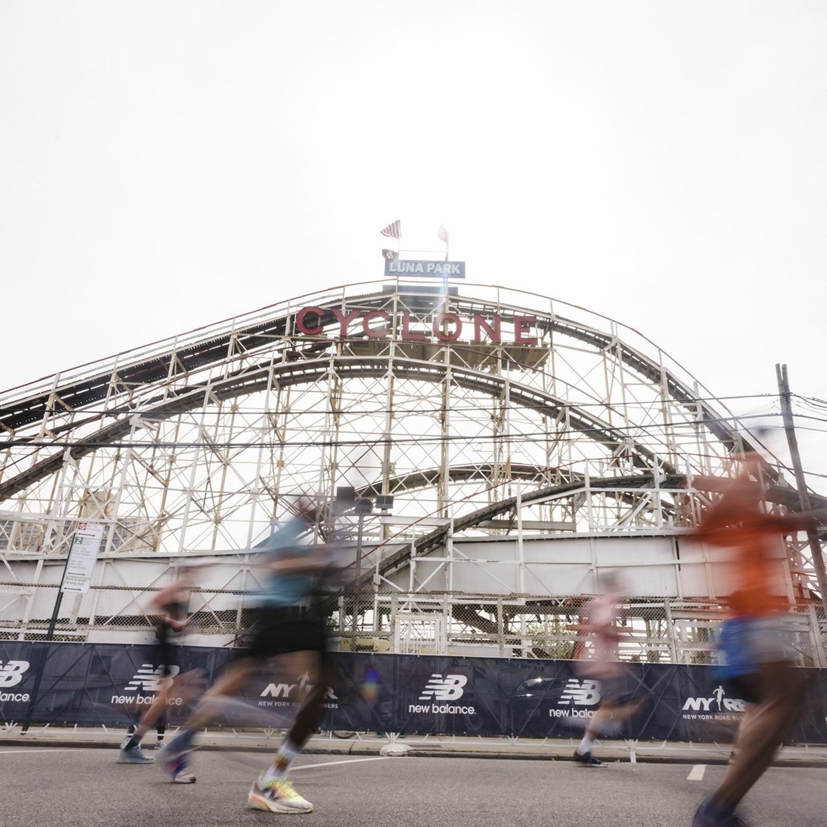 A blurry image of runners running past the Cyclone roller coaster in Coney Island for the RBC Brooklyn Half