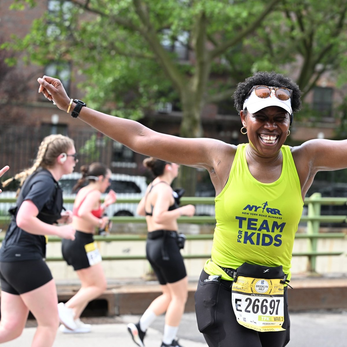 Team for Kids runner with arms outstretched at the RBC Brooklyn Half