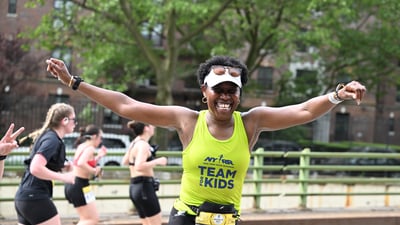 Team for Kids runner with arms outstretched at the RBC Brooklyn Half