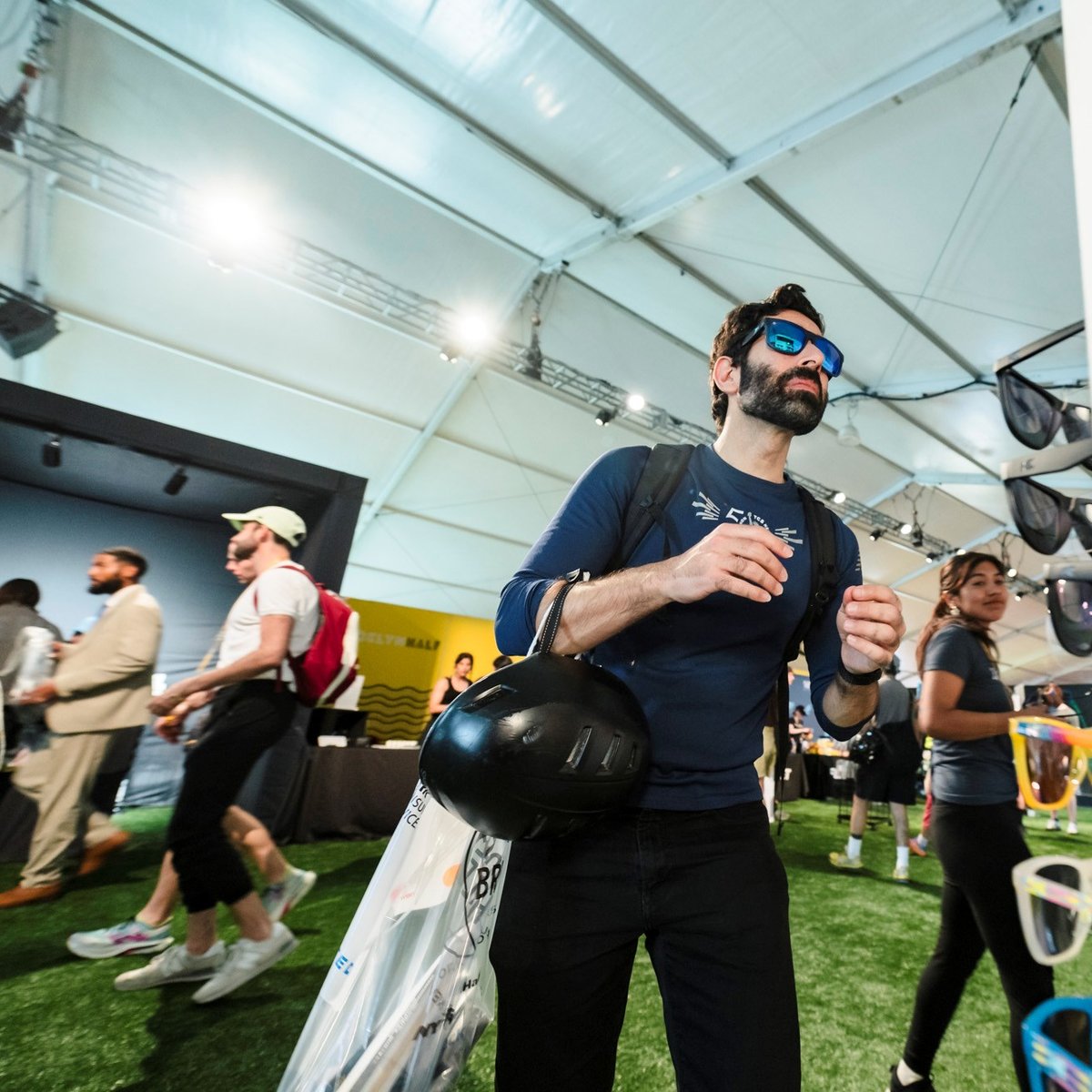 A man tries on a pair of Knockaround sunglasses at the 2025 RBC Brooklyn Half Pre-Party