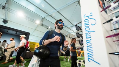A man tries on a pair of Knockaround sunglasses at the 2025 RBC Brooklyn Half Pre-Party