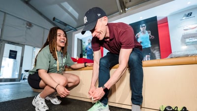 A man tries on New Balance sneakers at the 2025 RBC Brooklyn Half Pre-Party